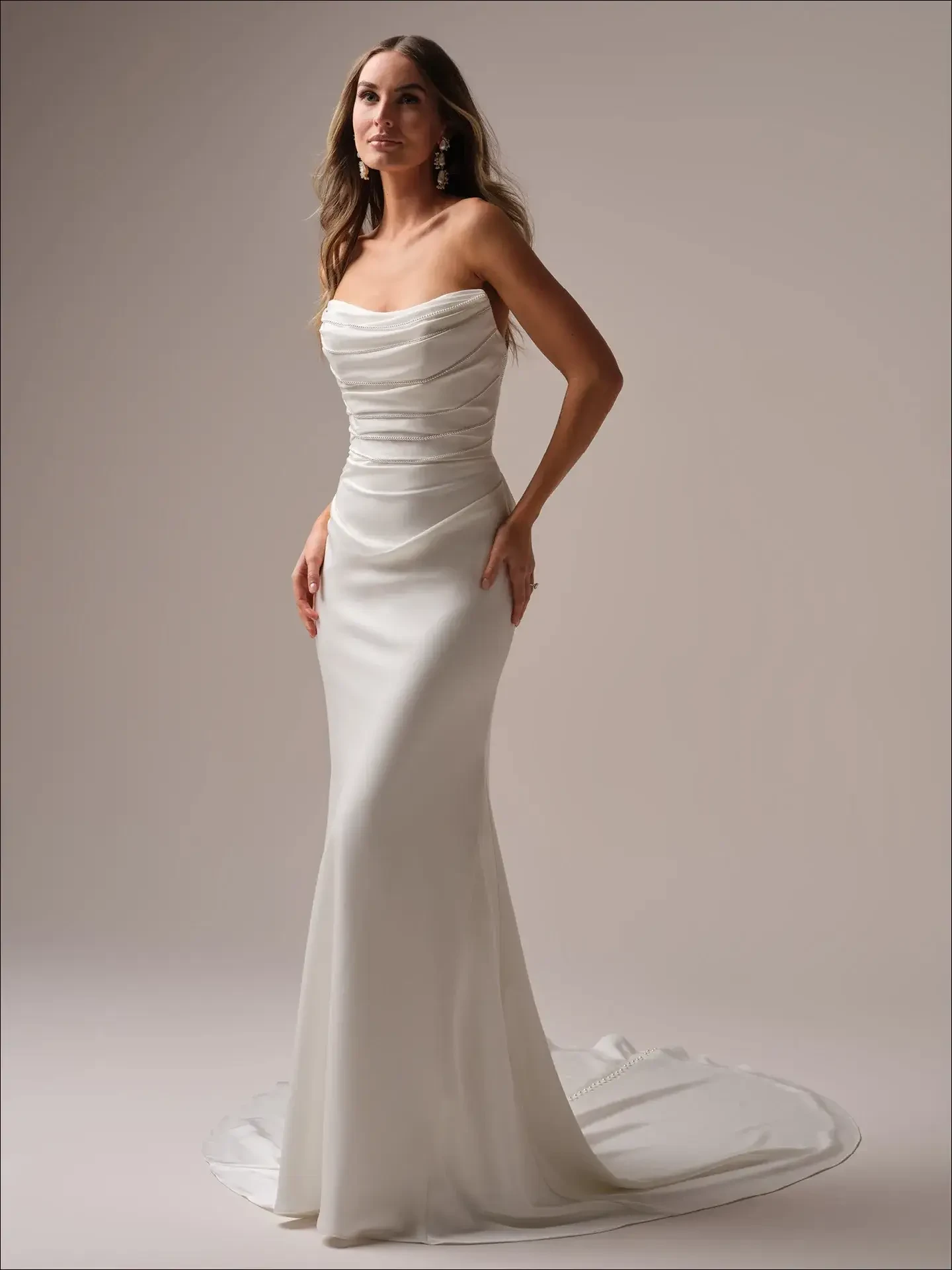 model is wearing a strapless fitted satin bridal gown