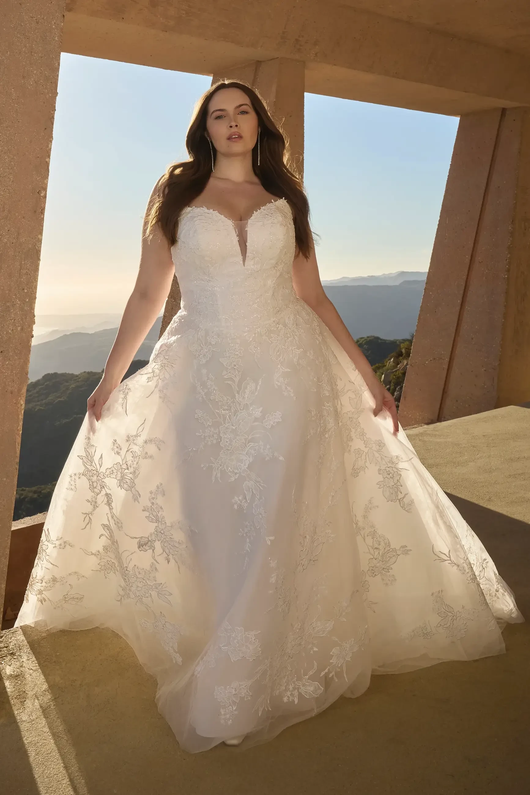 model is wearing a plus size lace bridal a-line dress