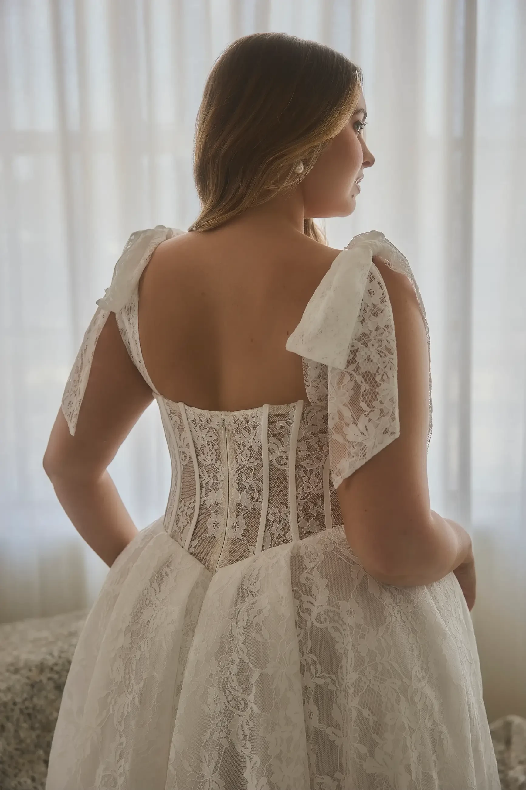model is wearing a plus size corset wedding dress with a slit