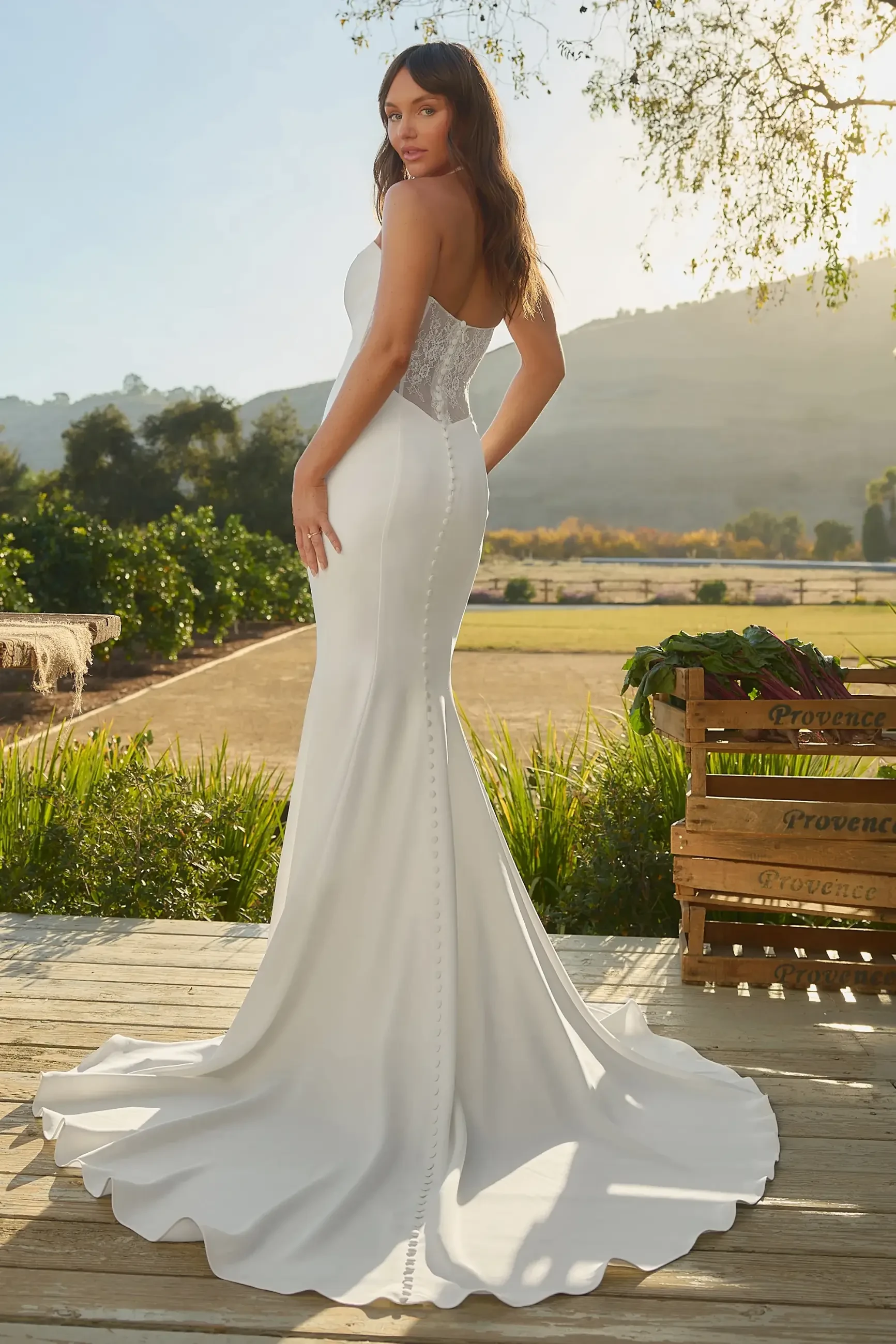 model is wearing a basque waist strapless fit and flare bridal gown