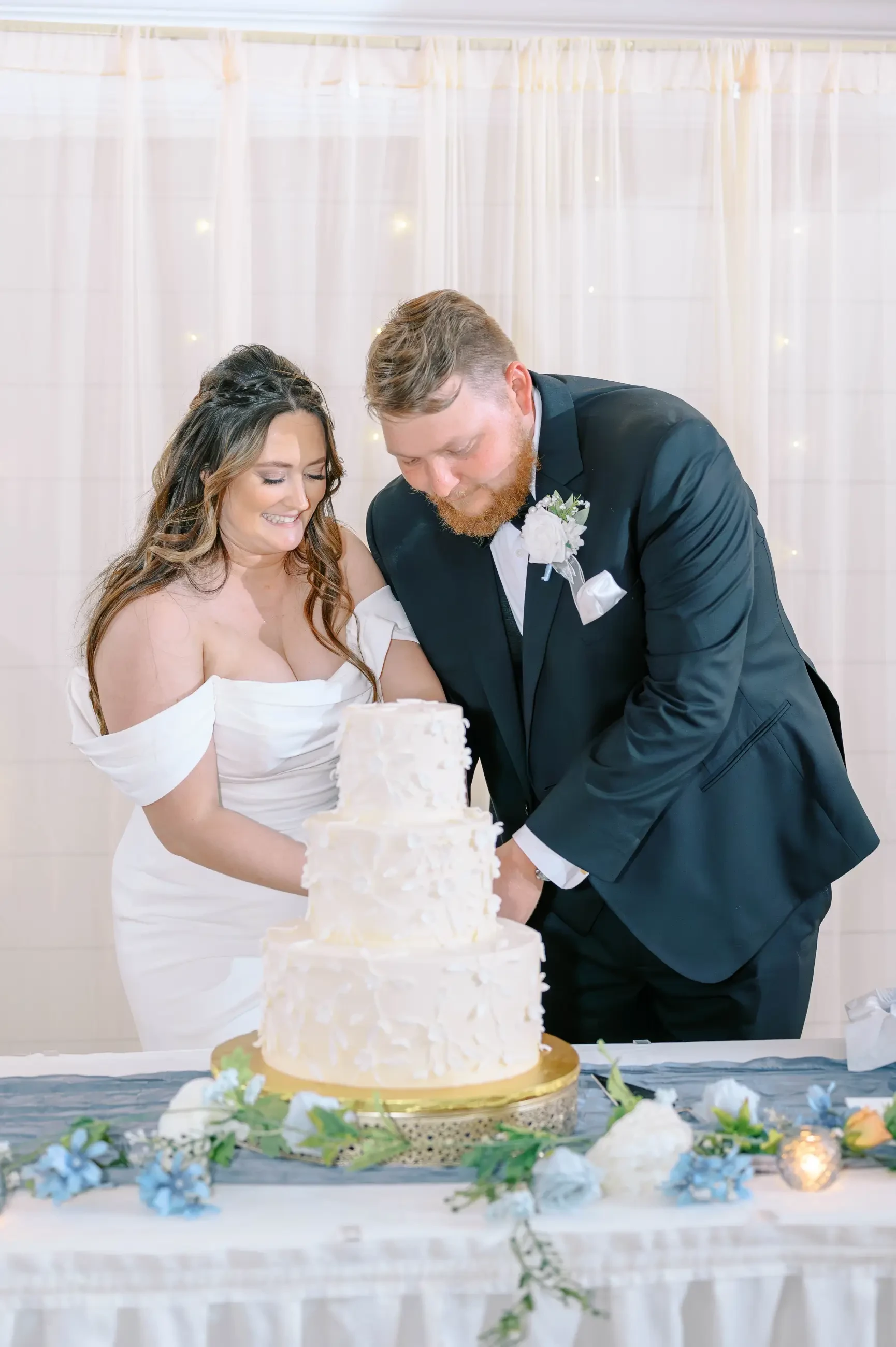 Virginia and James sharing a moment while slicing their wedding cake together.