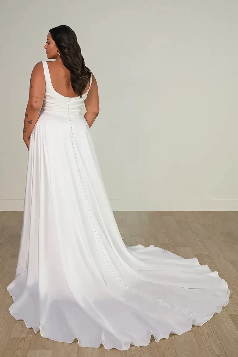 model is wearing a plus size sleeveless a-line wedding dress made of satin