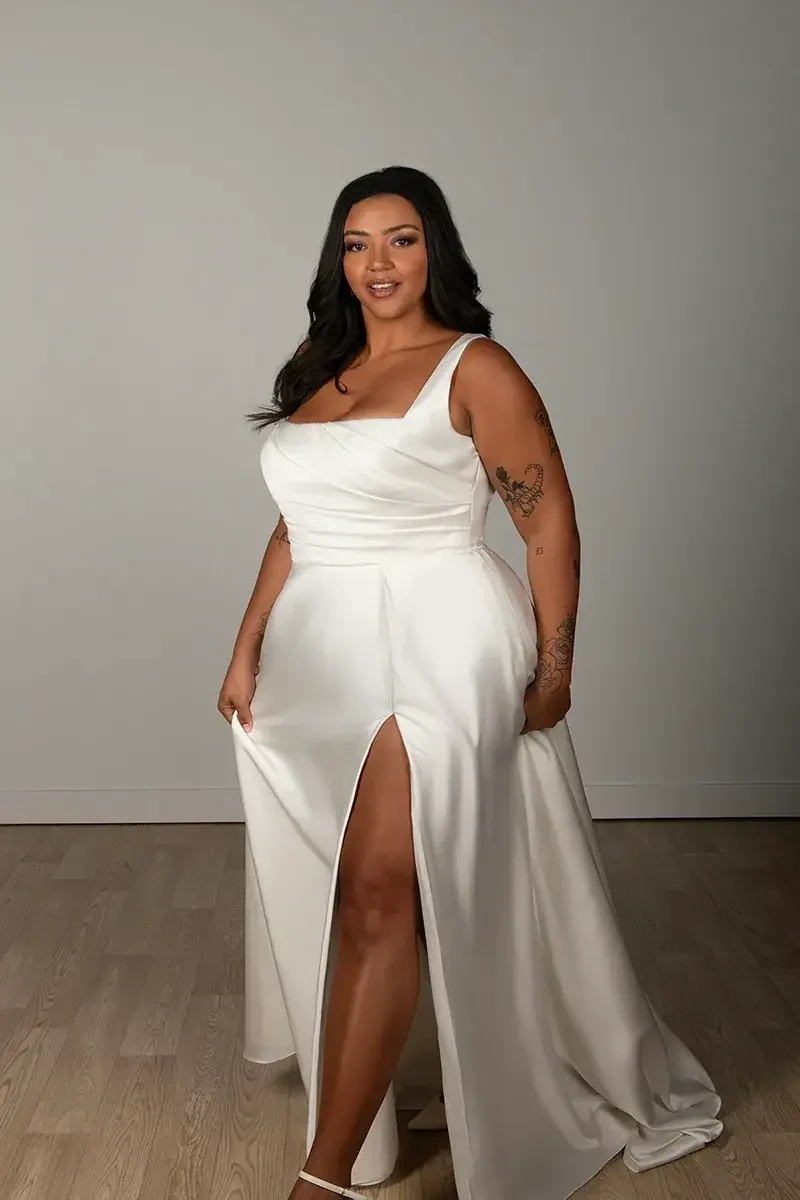 model is wearing a plus size sleeveless a-line wedding dress made of satin